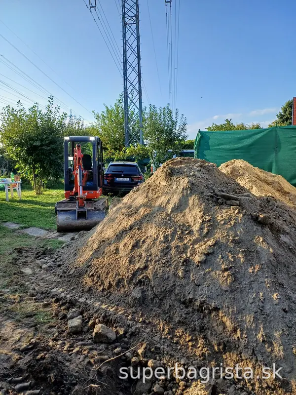 Minibager Kubota a vyťažená zemina pri výkope nádrže
