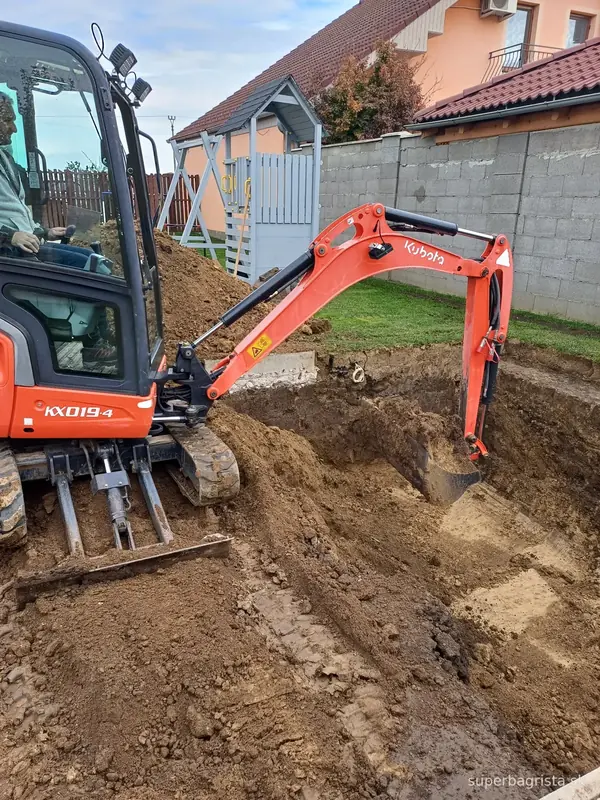Minibáger Kubota pri rozširovaní bazénovej jamy v záhrade