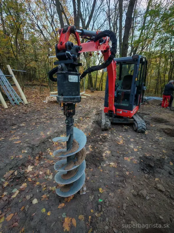 Minibáger Kubota s hydraulickým zemným vrtákom na pracovisku